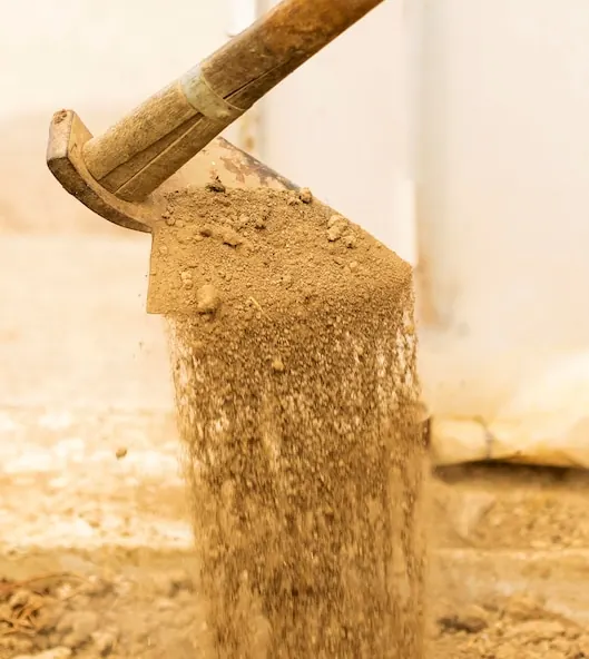 Sandy soil sliding off the blade of an old hoe
